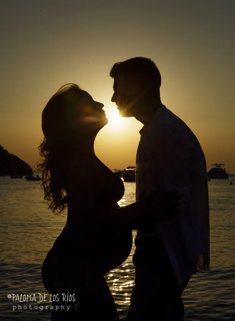 Pareja con mujer embarazada en una puesta de sol en la playa de Ibiza