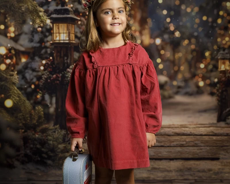 Primer plano de una niña mirando las luces navideñas con asombro. Fotografía infantil navideña realizada en Ibiza por Paloma de los Ríos.